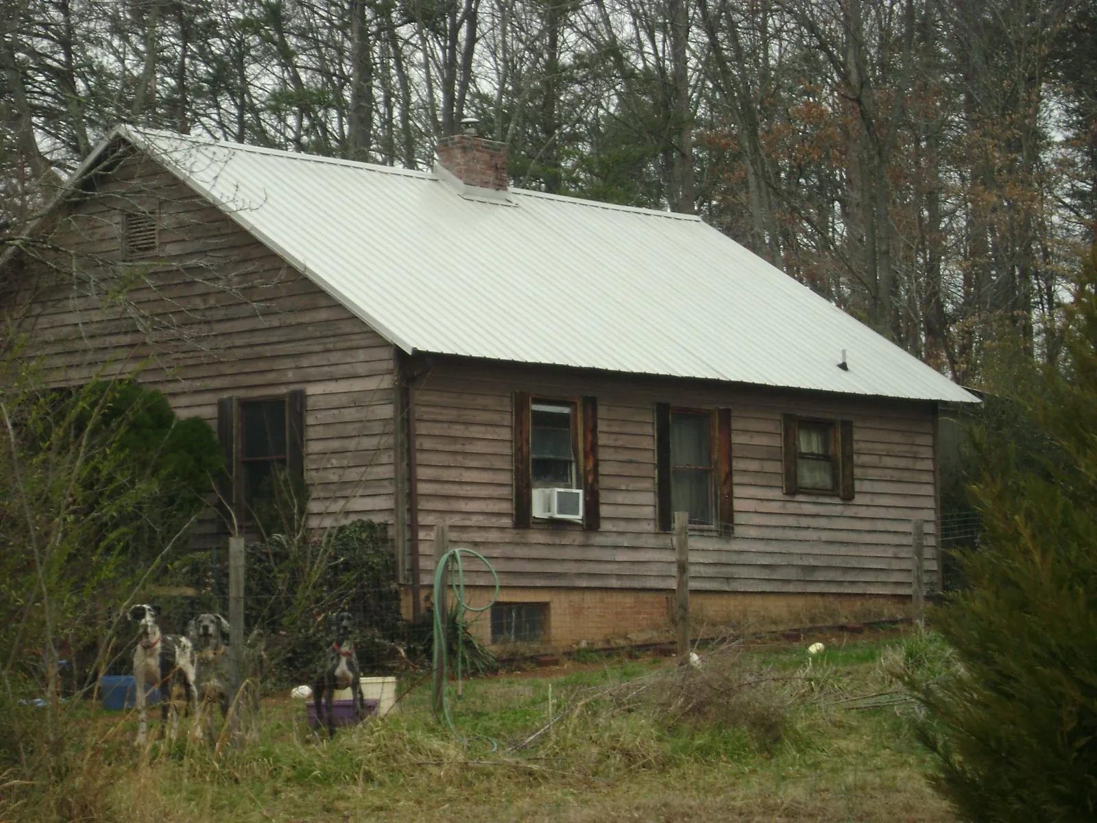 White metal roof on an old wood sided farmhouse, from a Metal Roof Installation job in Syracuse
